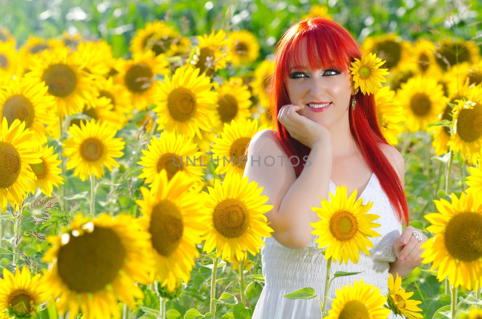 A pretty woman on blooming sunflower field in summer