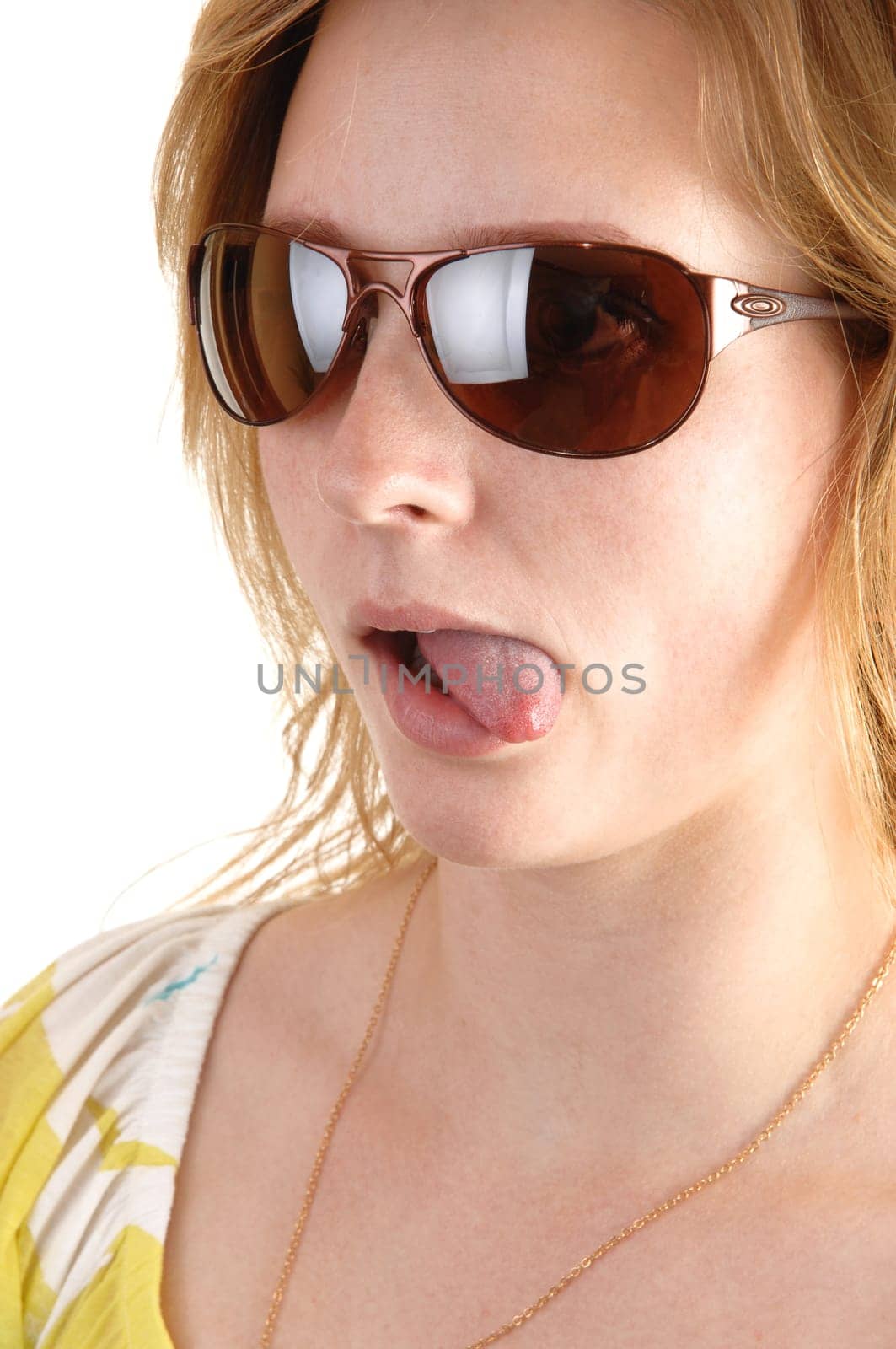 A blond woman with sunglasses in a portrait closeup shows her tongue, on white background.