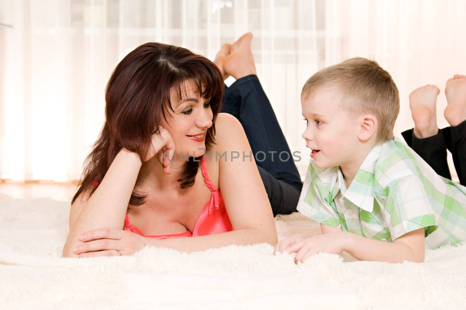 happy mother and son lie on the carpet