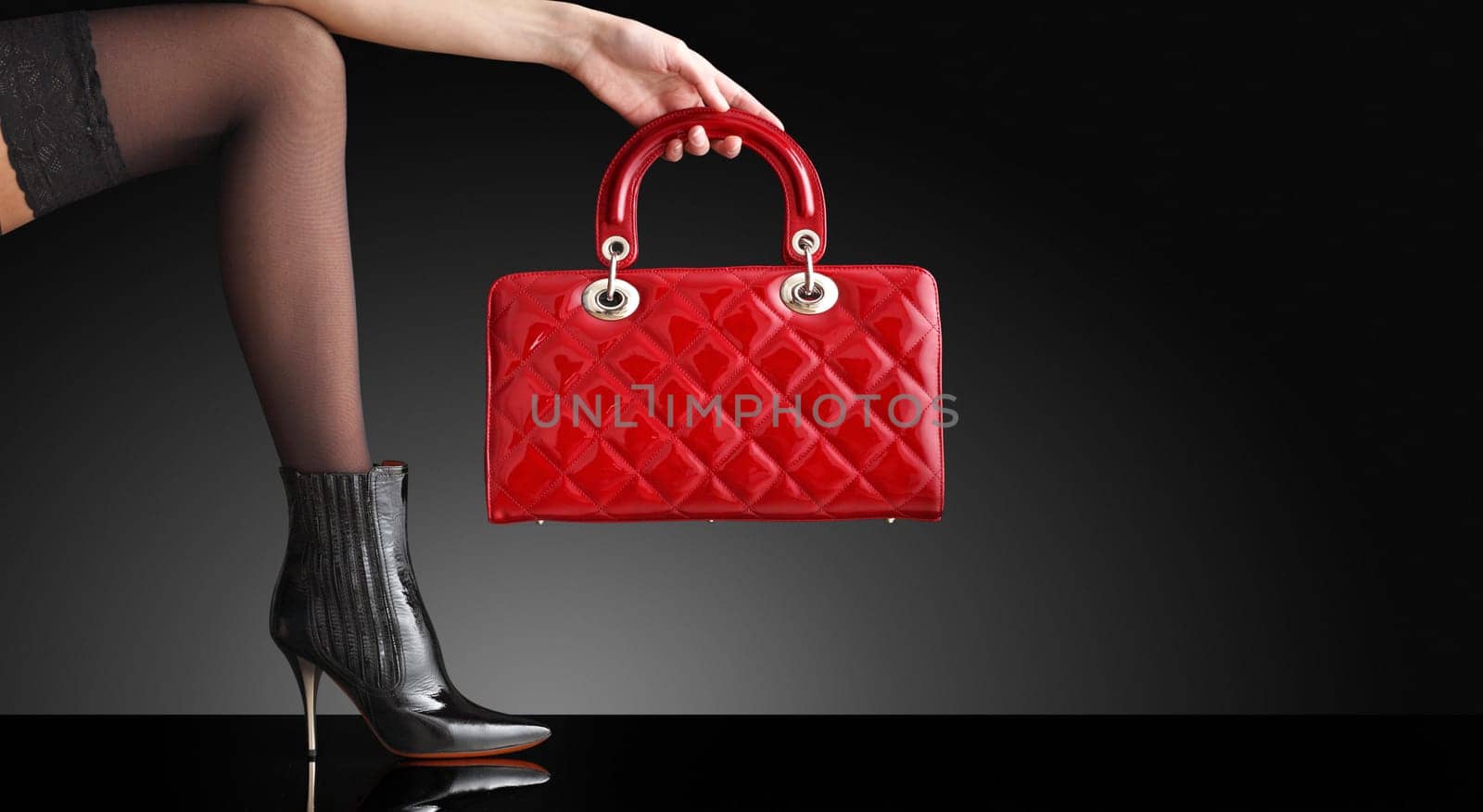 fashionable woman with a red handbag, only legs