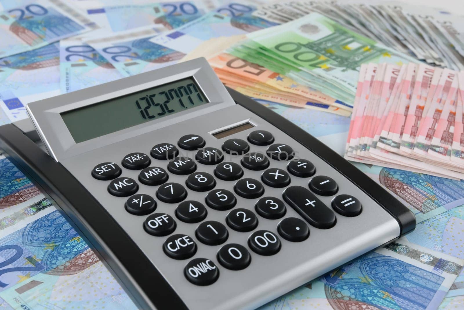 A calculator is lying on a carpet of banknotes