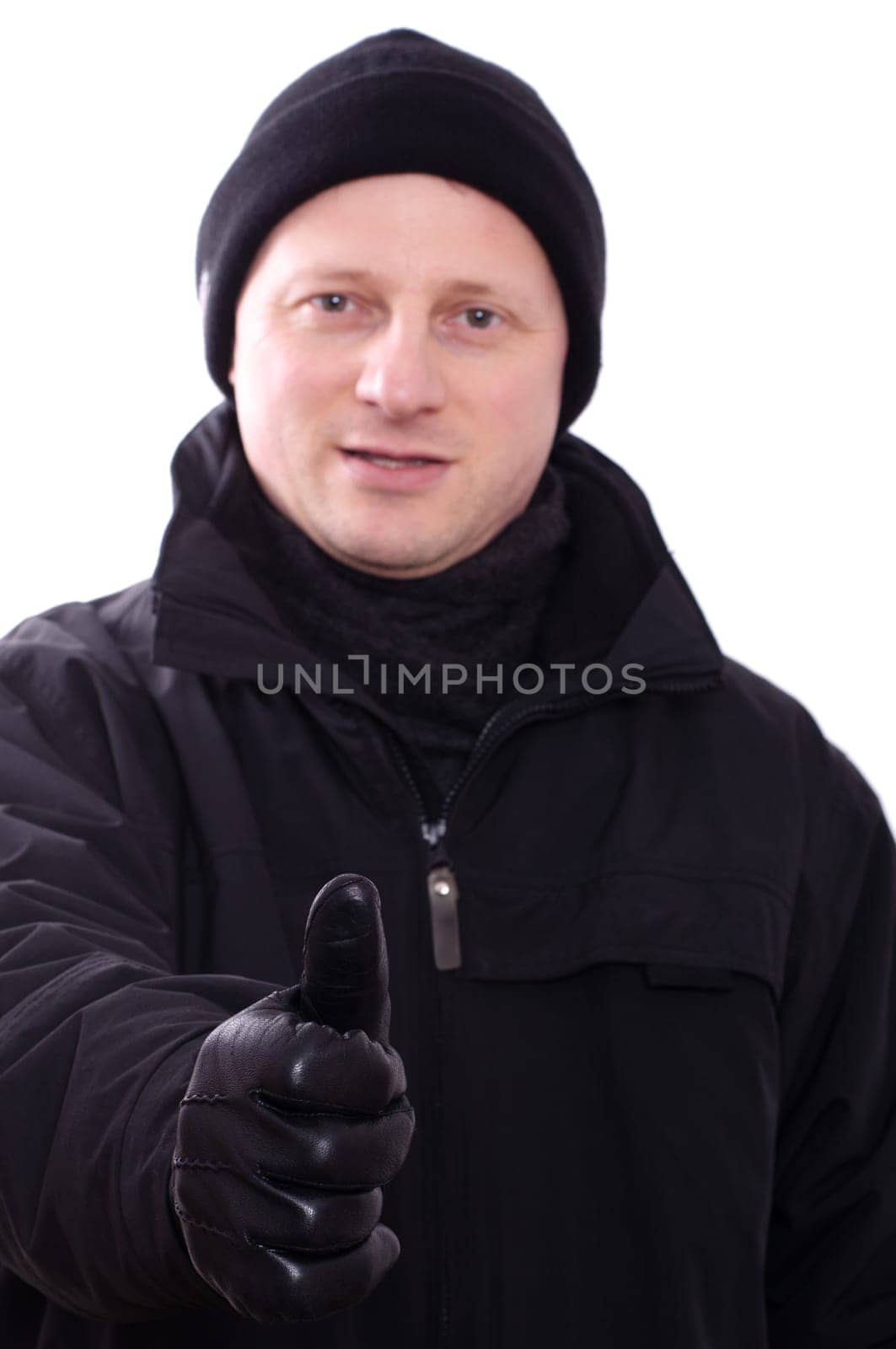 A man in winter clothes holds a thumbs up