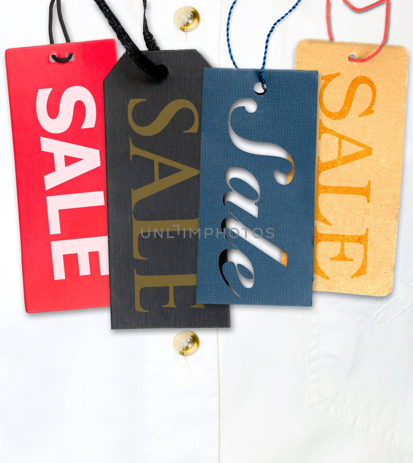 Tags With Sale Sign With Stack of White Shirt in Background