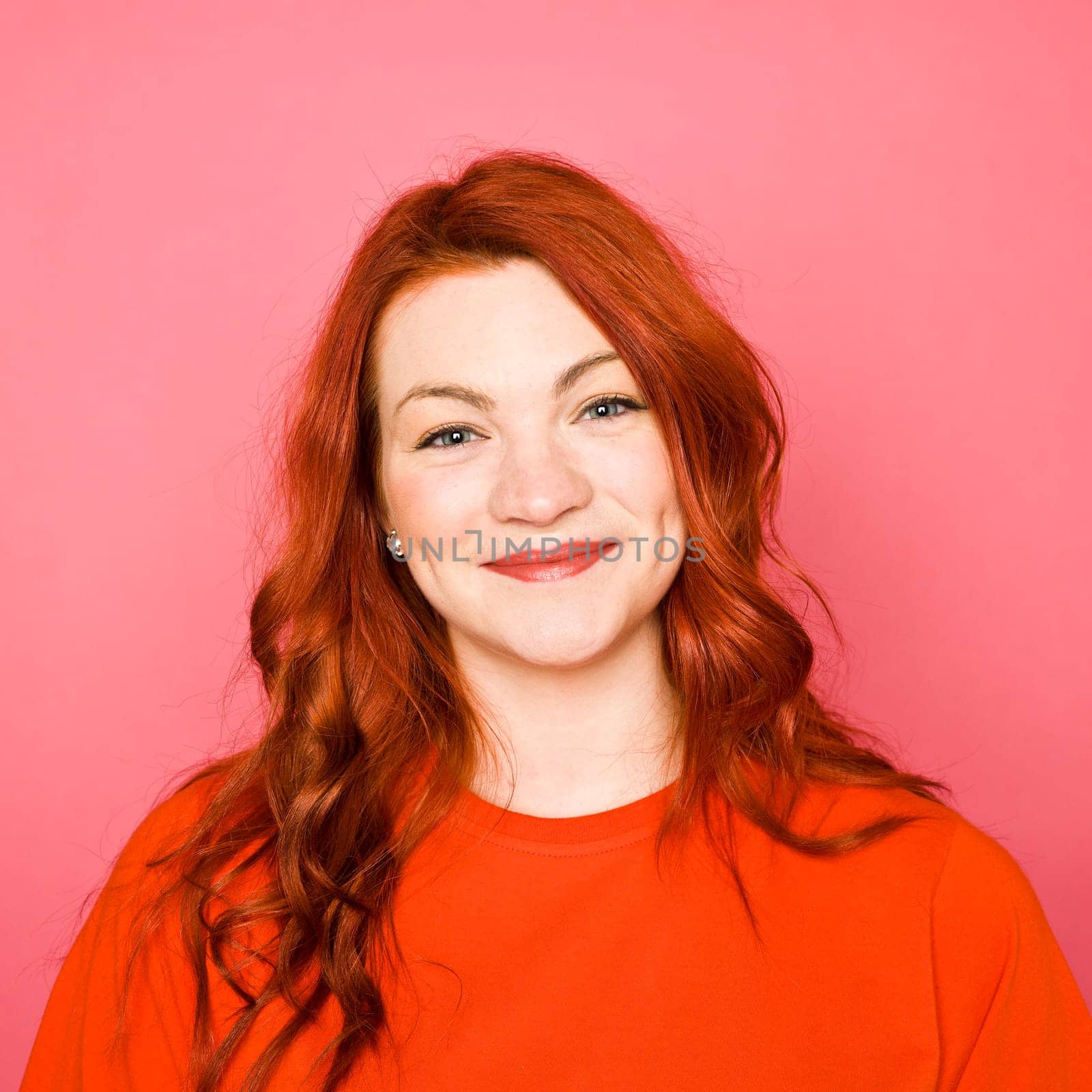 Woman with red hair on pink background