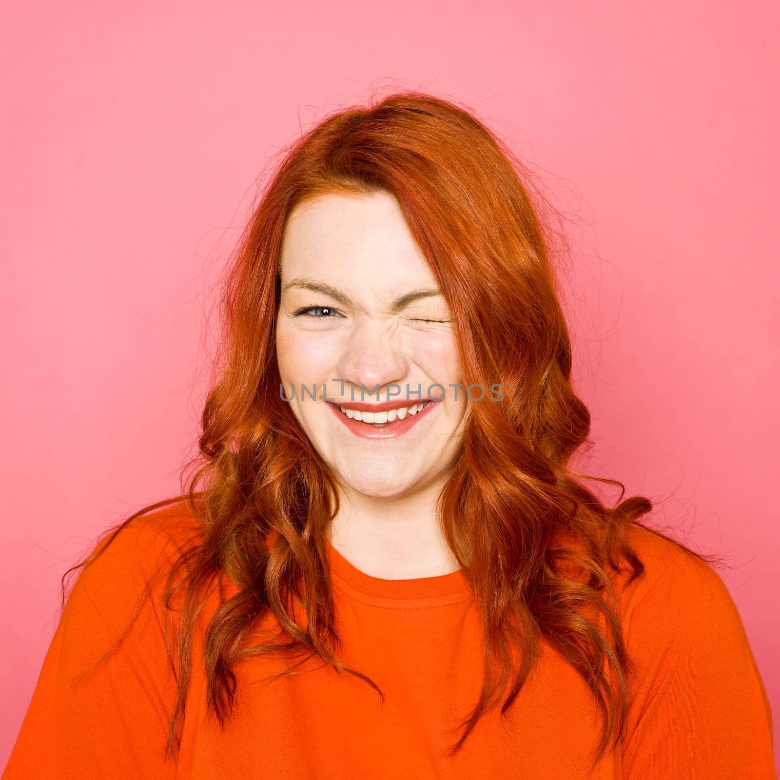 Woman with red hair on pink background