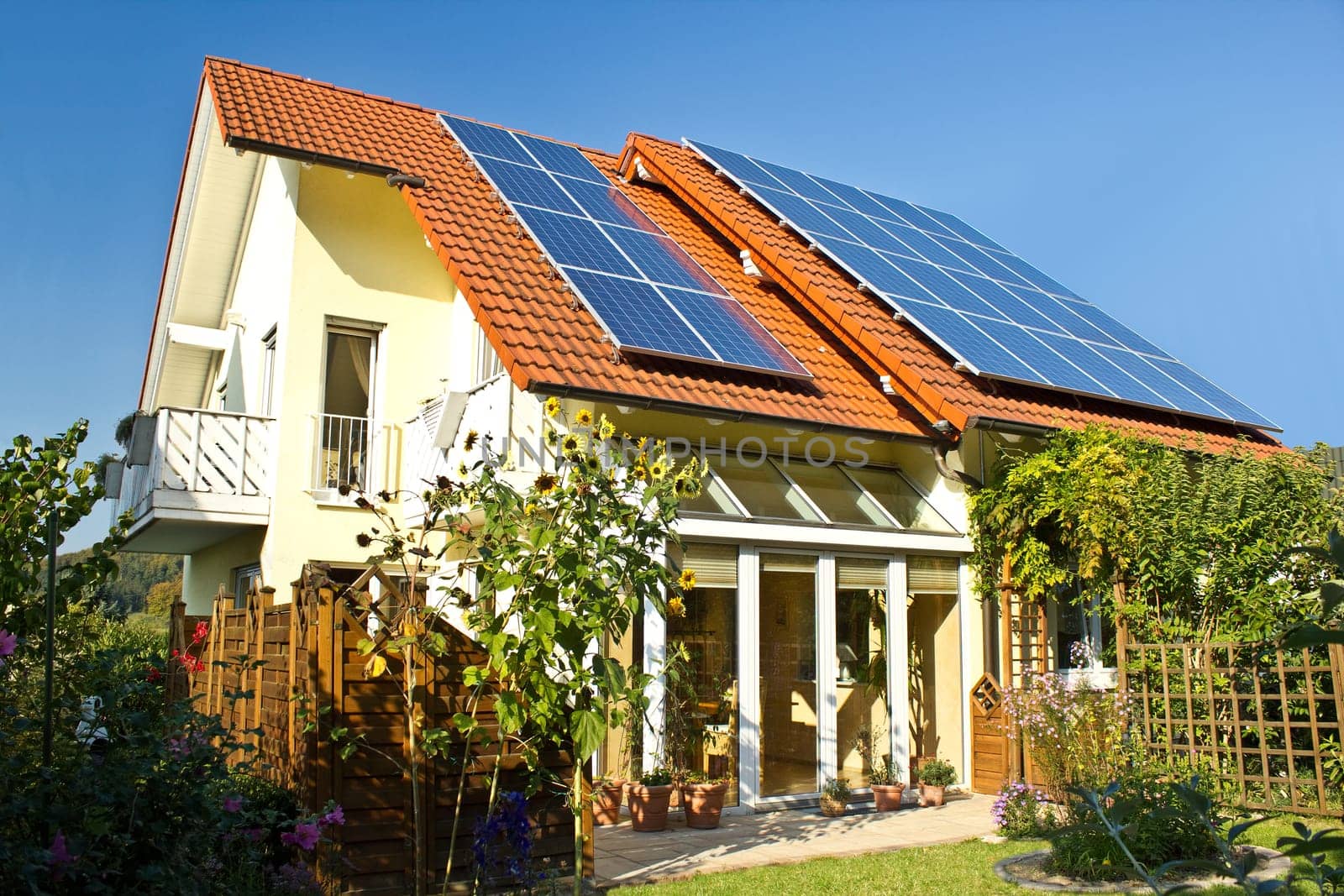House with garden and solar panels on the roof