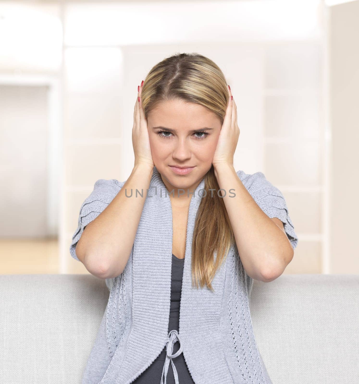Young woman holding hands on ears