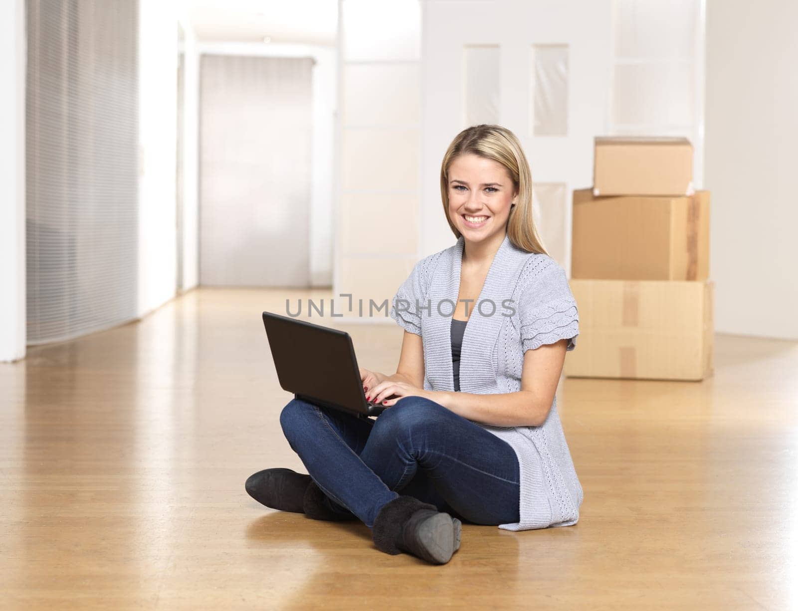 Young woman with notebook in front of moving boxes