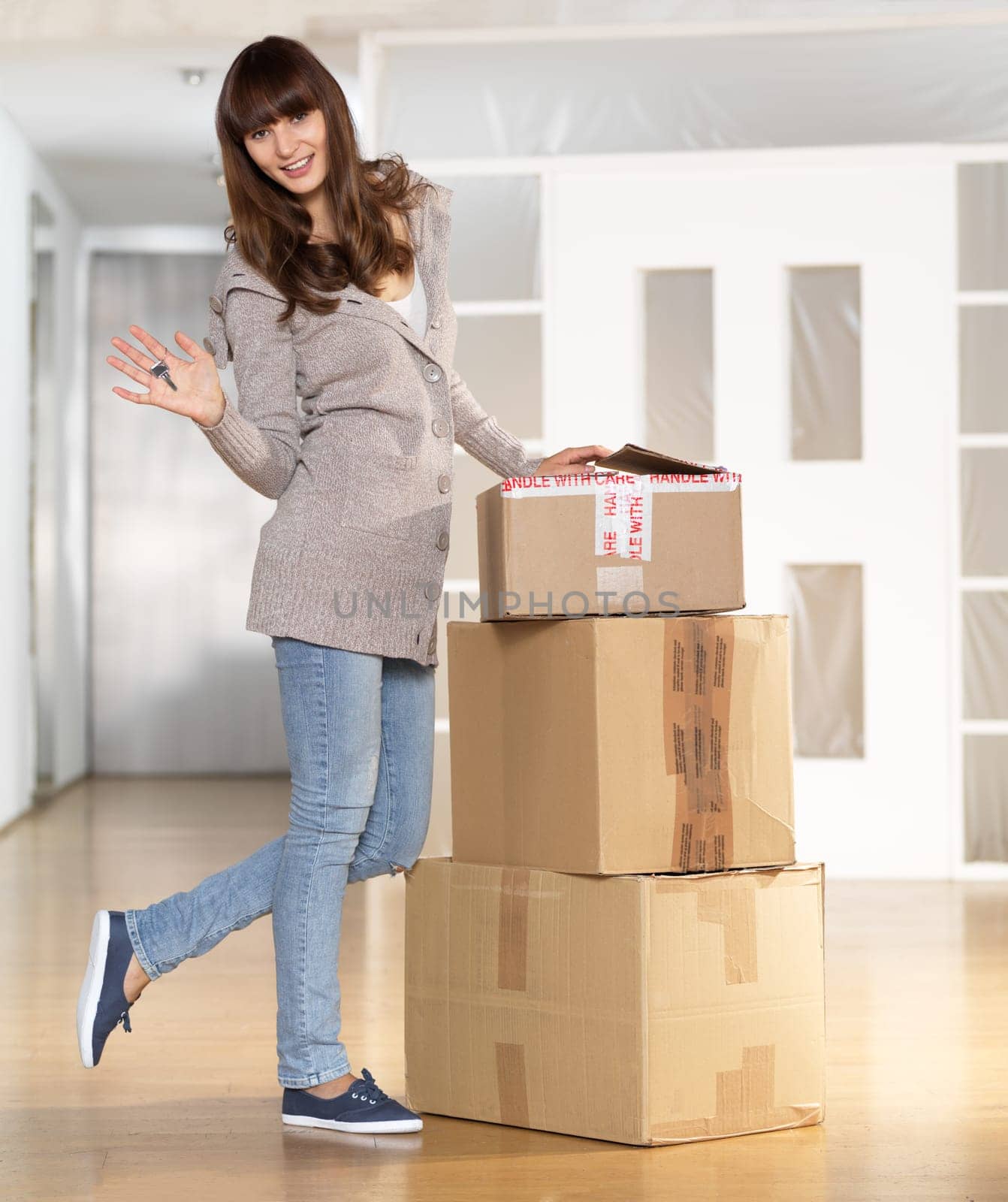 Young woman with key to her new apartment