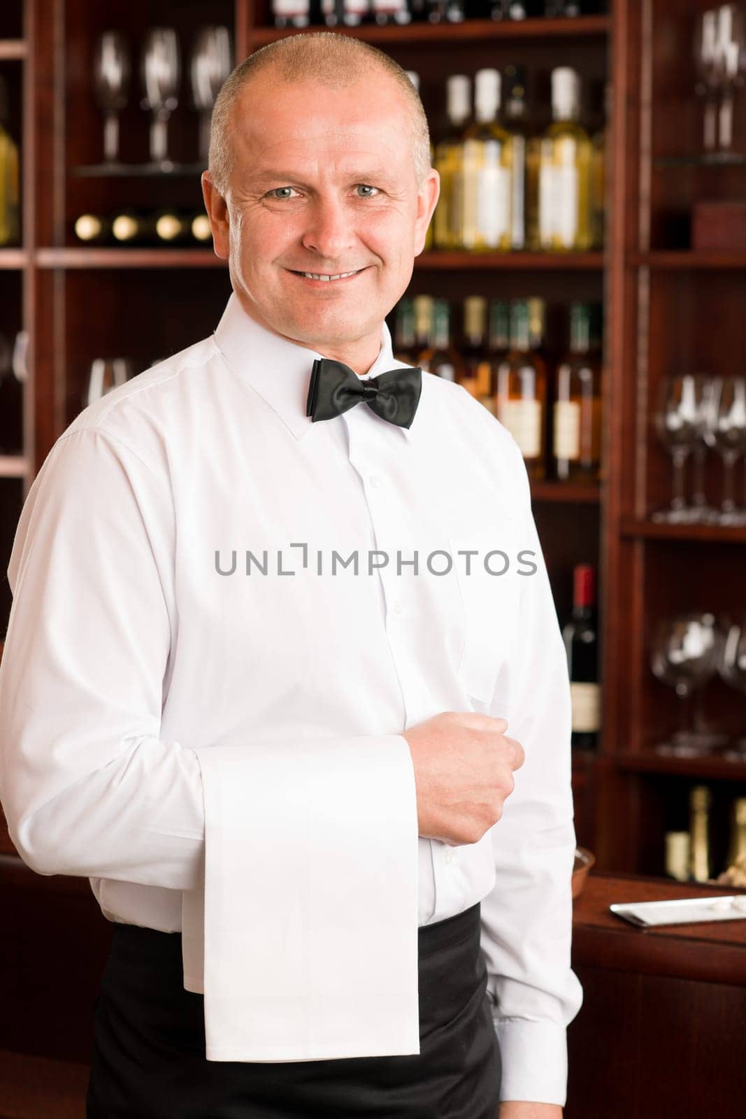 Wine bar waiter mature smiling in restaurant front of counter