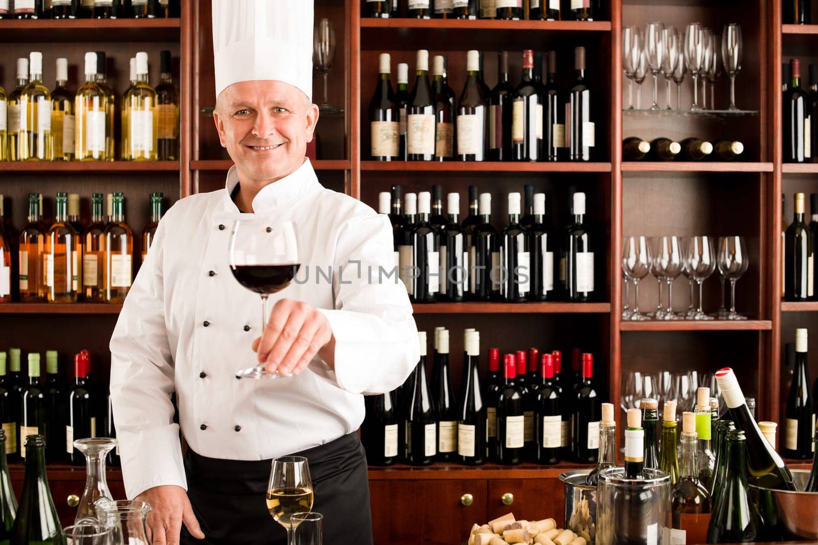 Chef cook smiling serve glass of red wine restaurant bar