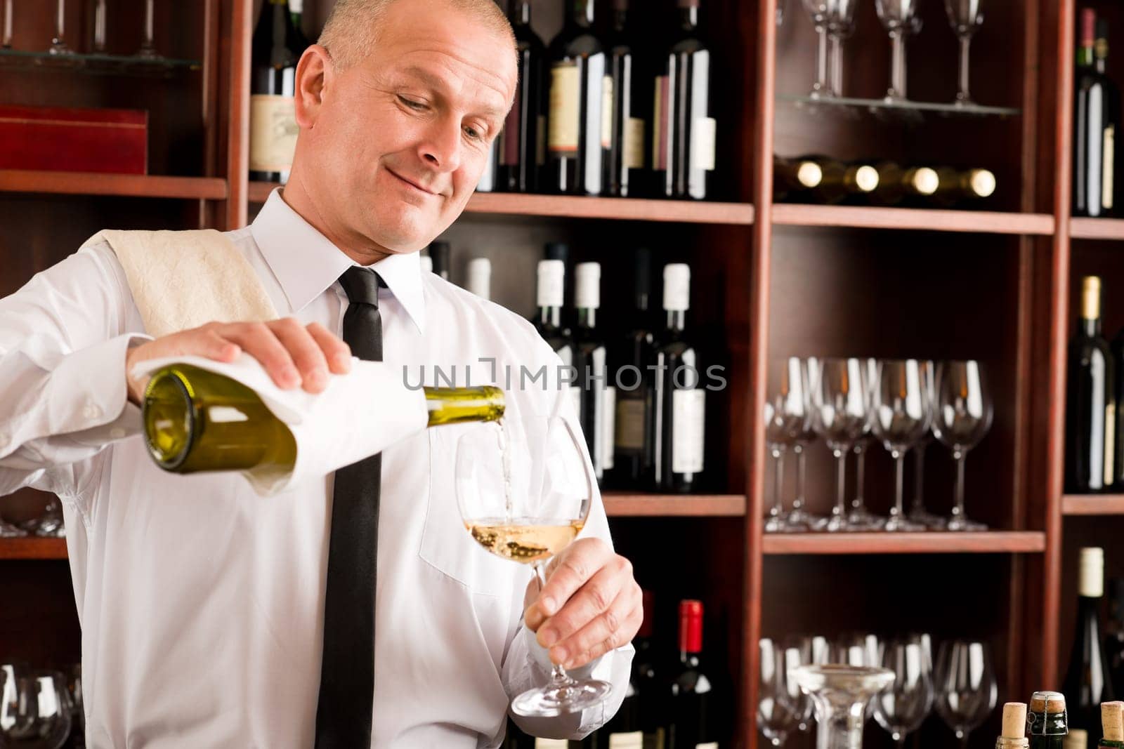 Wine bar happy waiter pour white wine in glass restaurant
