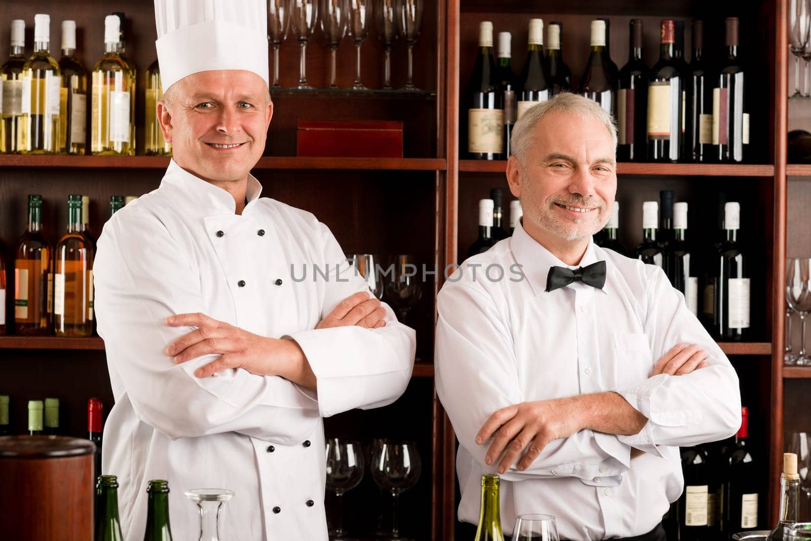 Chef cook and waiter smiling in restaurant wine bar