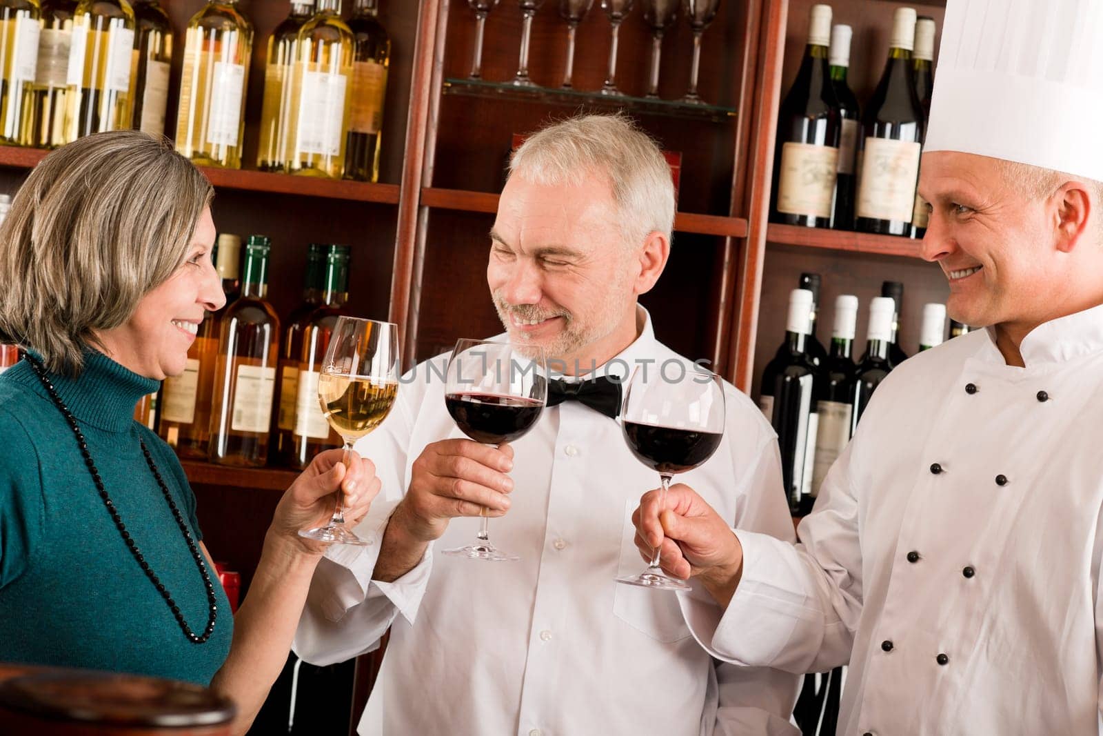 Restaurant manager posing with chef cook and waiter wine bar