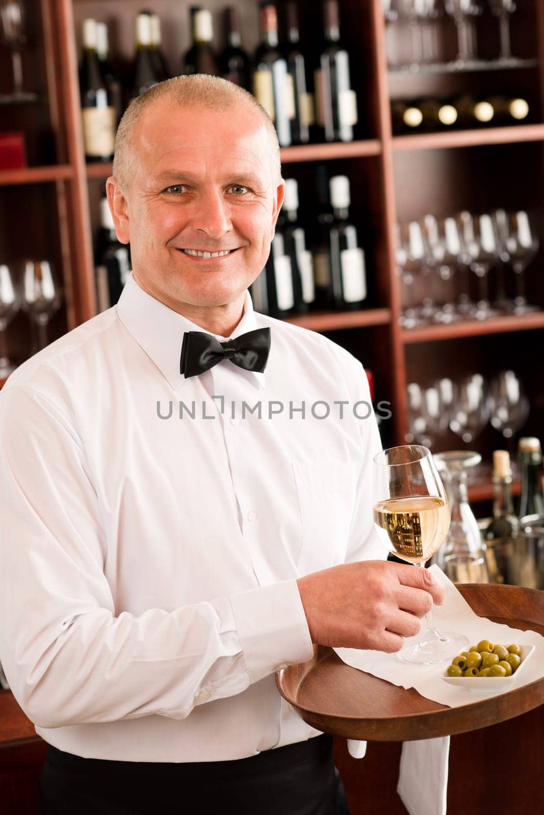 Wine bar waiter mature serving on tray glass olives restaurant