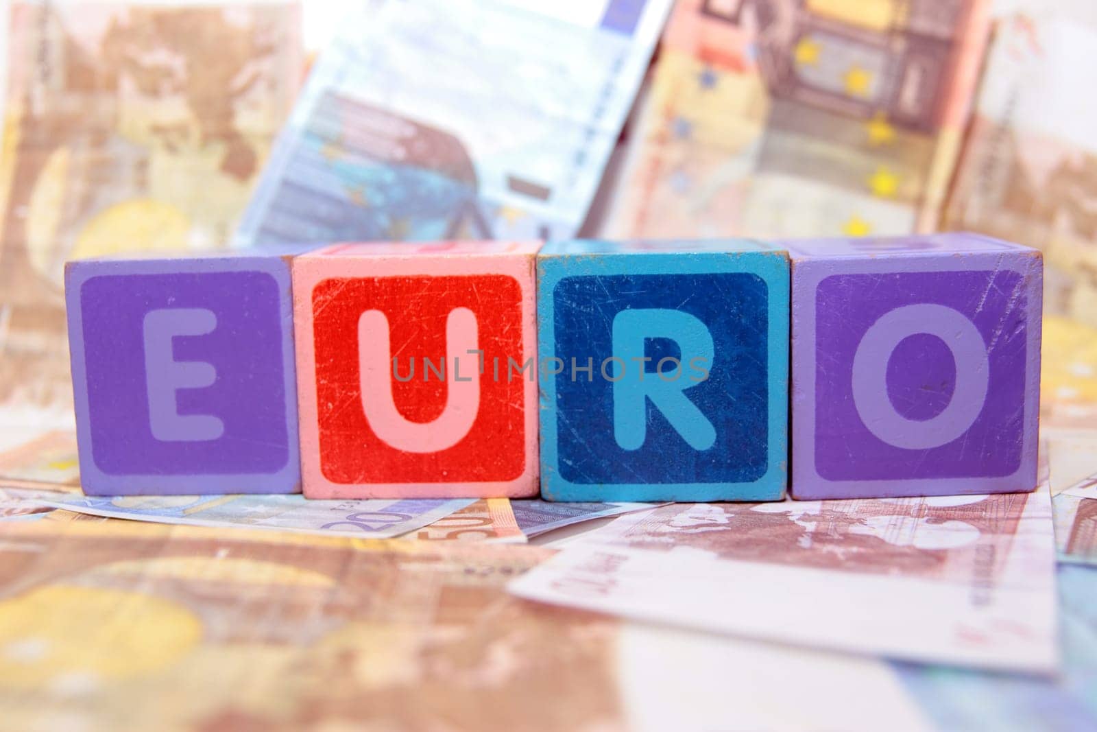 toy letters that spell euro against a cash background