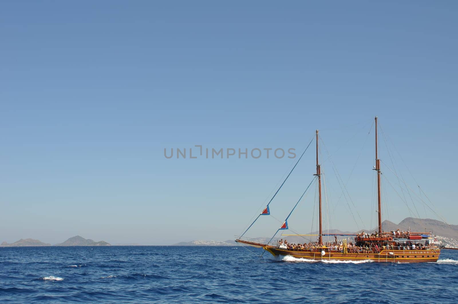 KOS - AUGUST 26 2010: passengers on board, antique ship is cruising the blue sea on August 26, 2010 in Kos, GREECE
