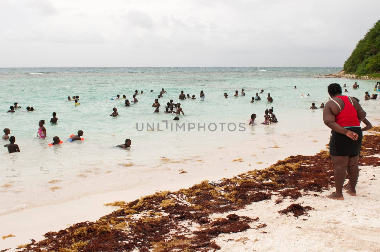 LONG BAY, WILLIKIES - AUGUST 20 2011: teacher as lifeguard at the beach with many children having a good time on August 20, 2011 in Long Bay, ANTIGUA