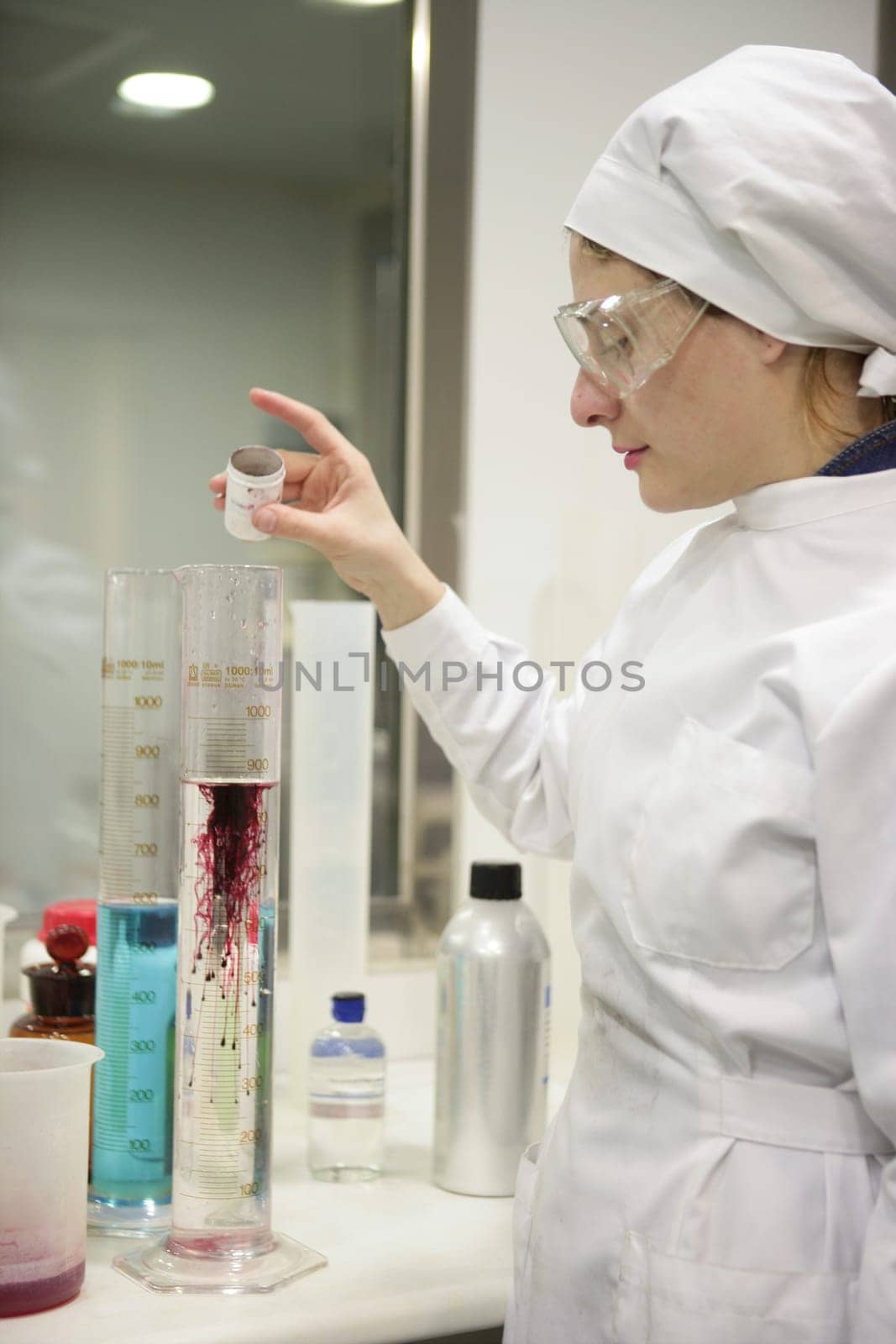 Chemical research laboratory, woman working, glass cylinder vase