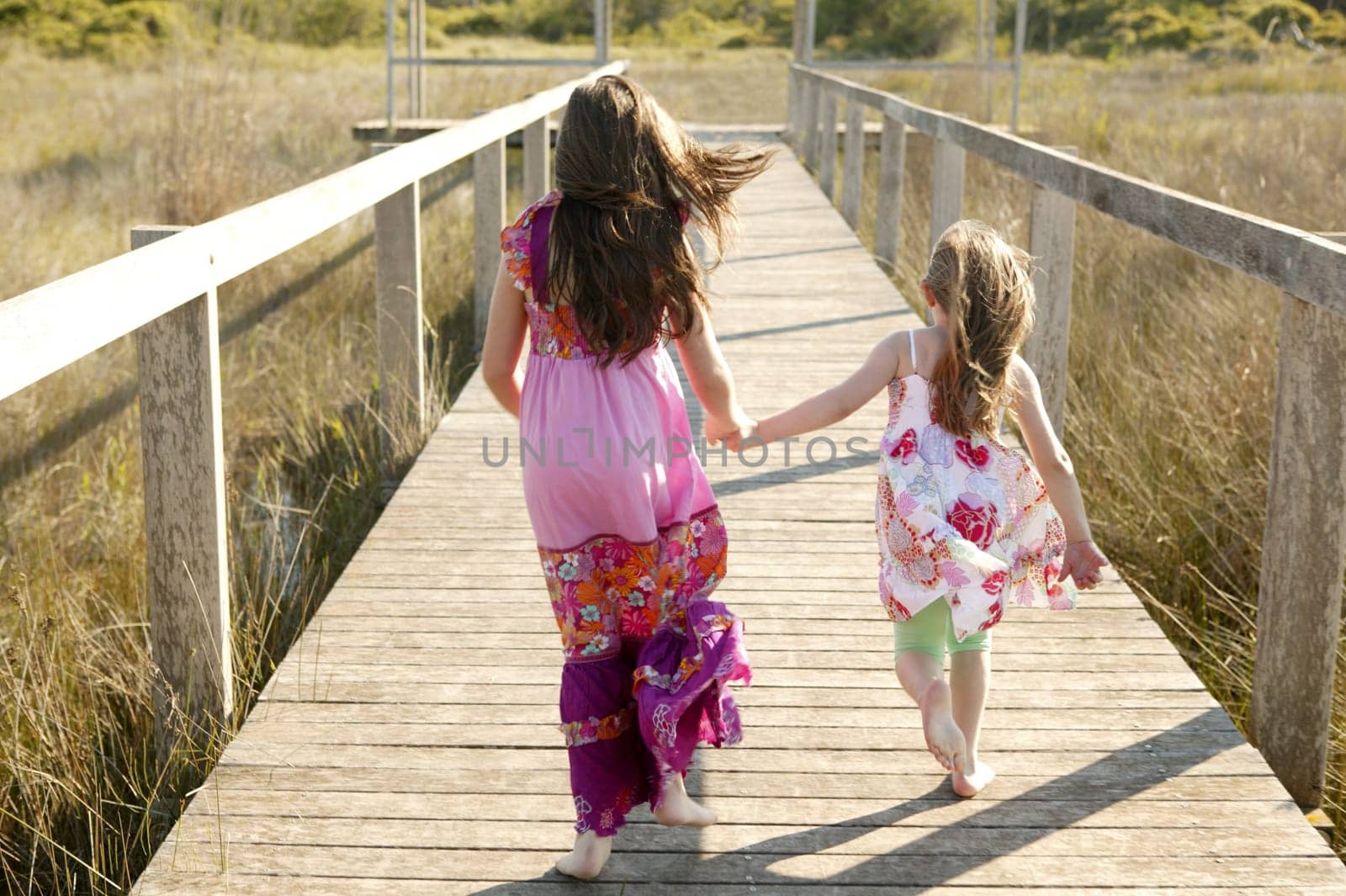 Teen two girls running outdoor at the park, hippy pink dress