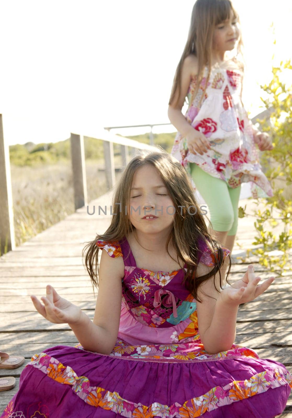 Hippy purple dress teen girl relaxed outdoors, sitting over the park wood