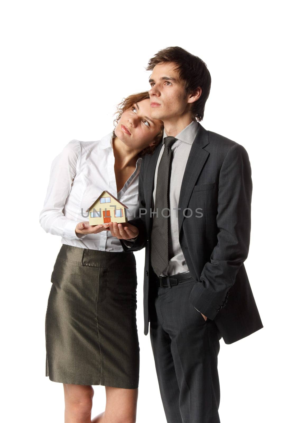 The young happy family holds house model in hands on a white background. House purchase concept.