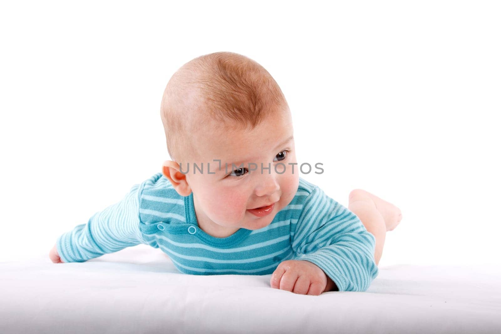 The nice small child in striped rompers lays on a stomach on a white background.