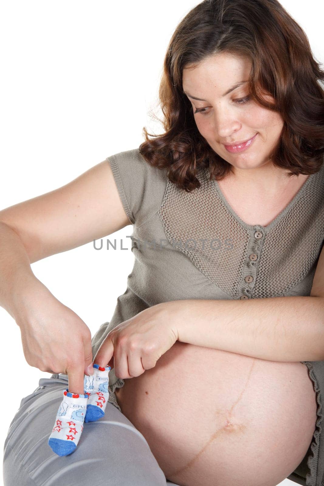 The young pregnant woman expecting a birth of the child, holds bootees