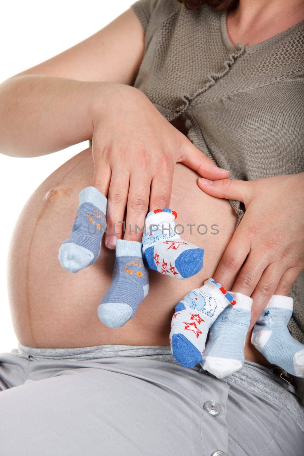 The young pregnant woman expecting a birth of the child, holds bootees