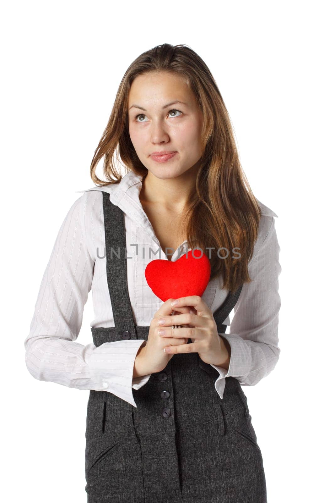 The beautiful girl holds in hands a red heart on a white background.