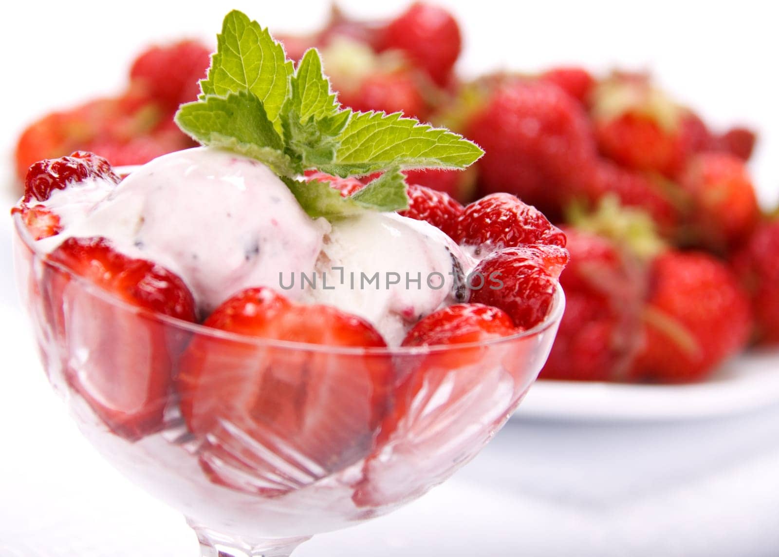 Ice-cream with fresh berries of a strawberry on a white background.