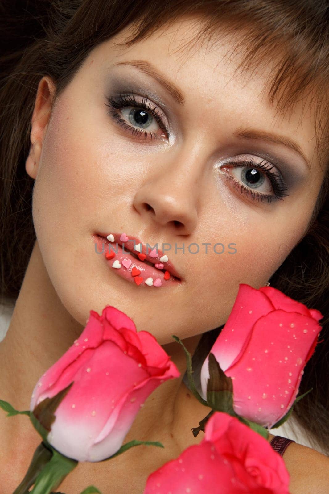 The beautiful girl with a bouquet of roses on a white background.