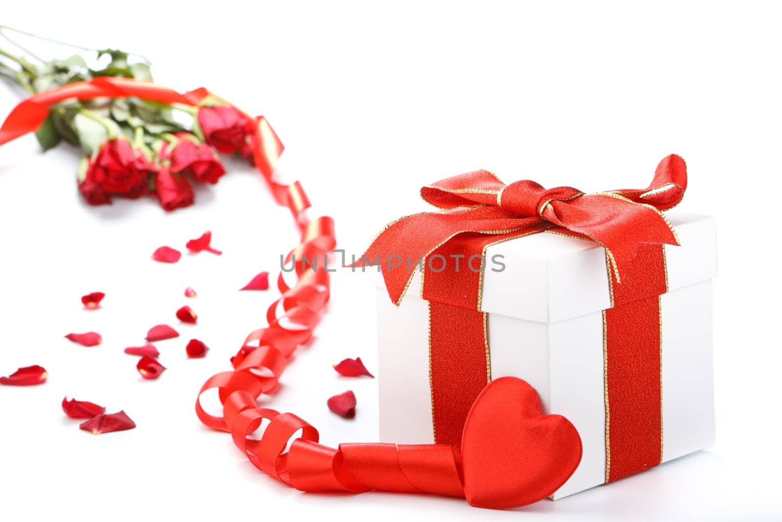 Gift box with red ribbon and flower on a white background