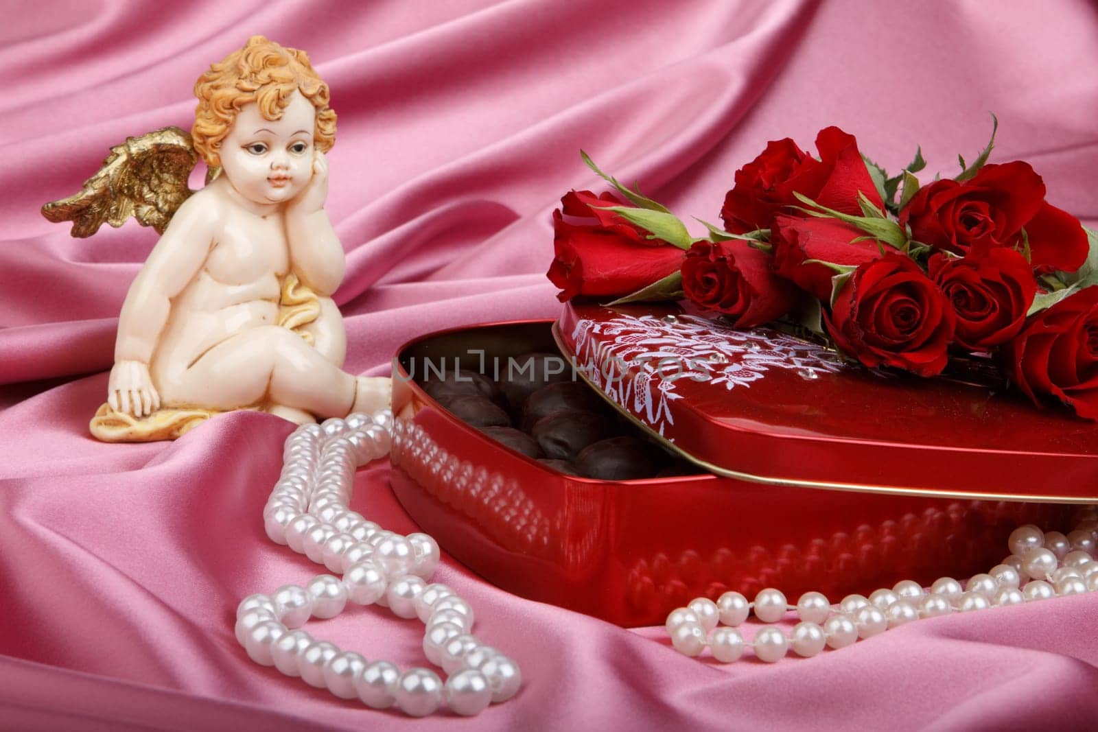 Heart-shaped red box with sweets, cupid and flowers. Valentine&#039 s day card.