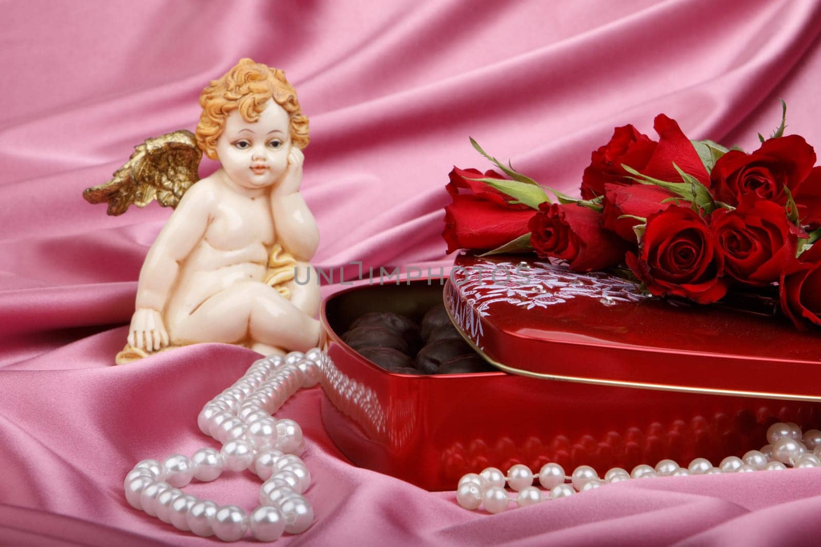 Heart-shaped red box with sweets, cupid and flowers. Valentine&#039 s day card.