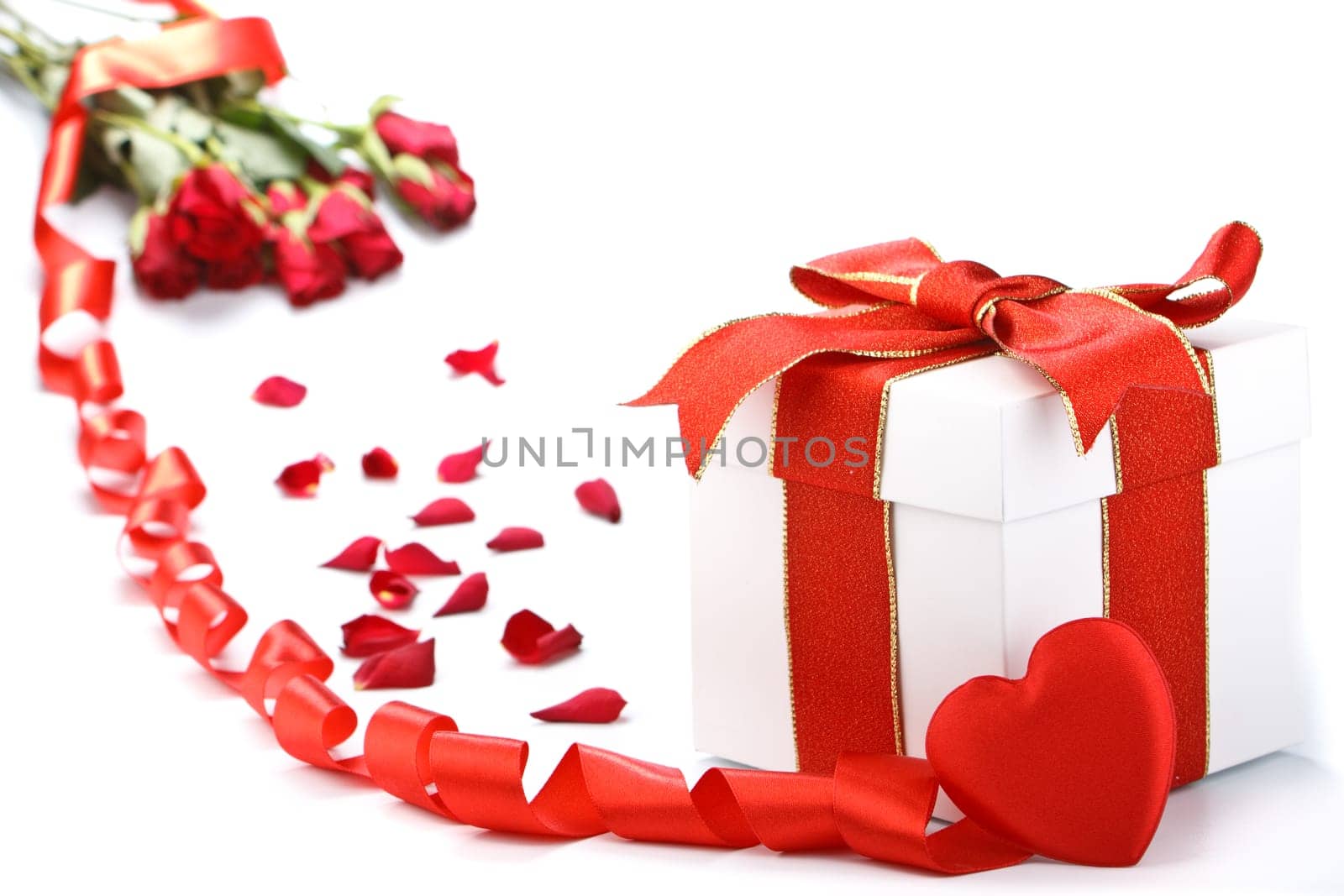 Gift box with red ribbon and flower on a white background