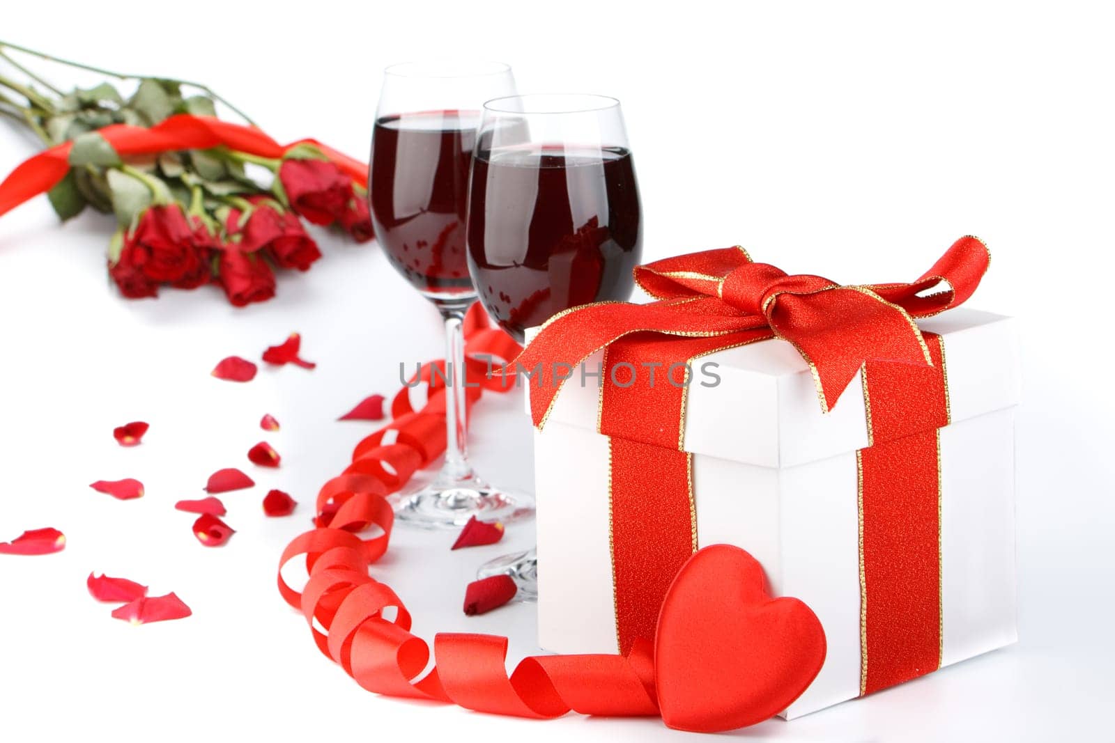 Gift box with red ribbon and flower on a white background