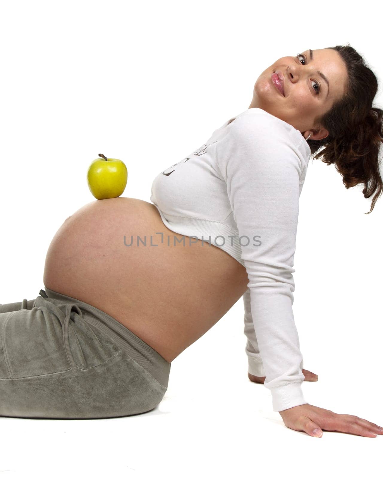 Beautiful pregnant woman with an apple on a white background