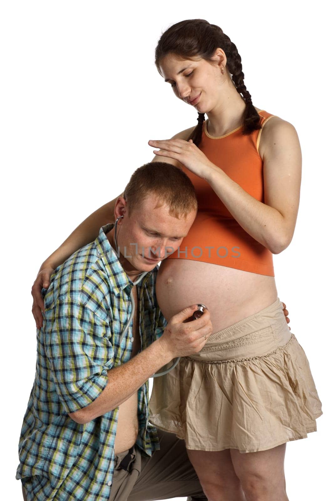 Young father listening heartbeat of his future child on a white background