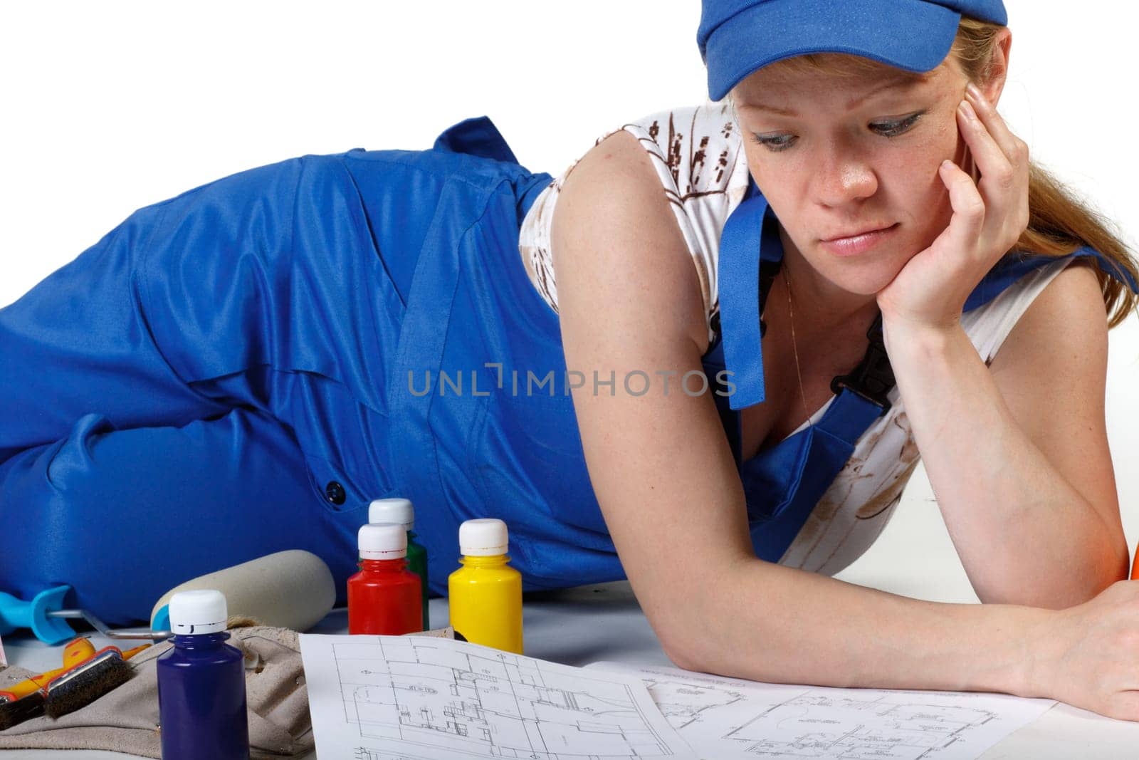 The pregnant woman dressed in working overalls, chooses colour for a children&#039 s room.