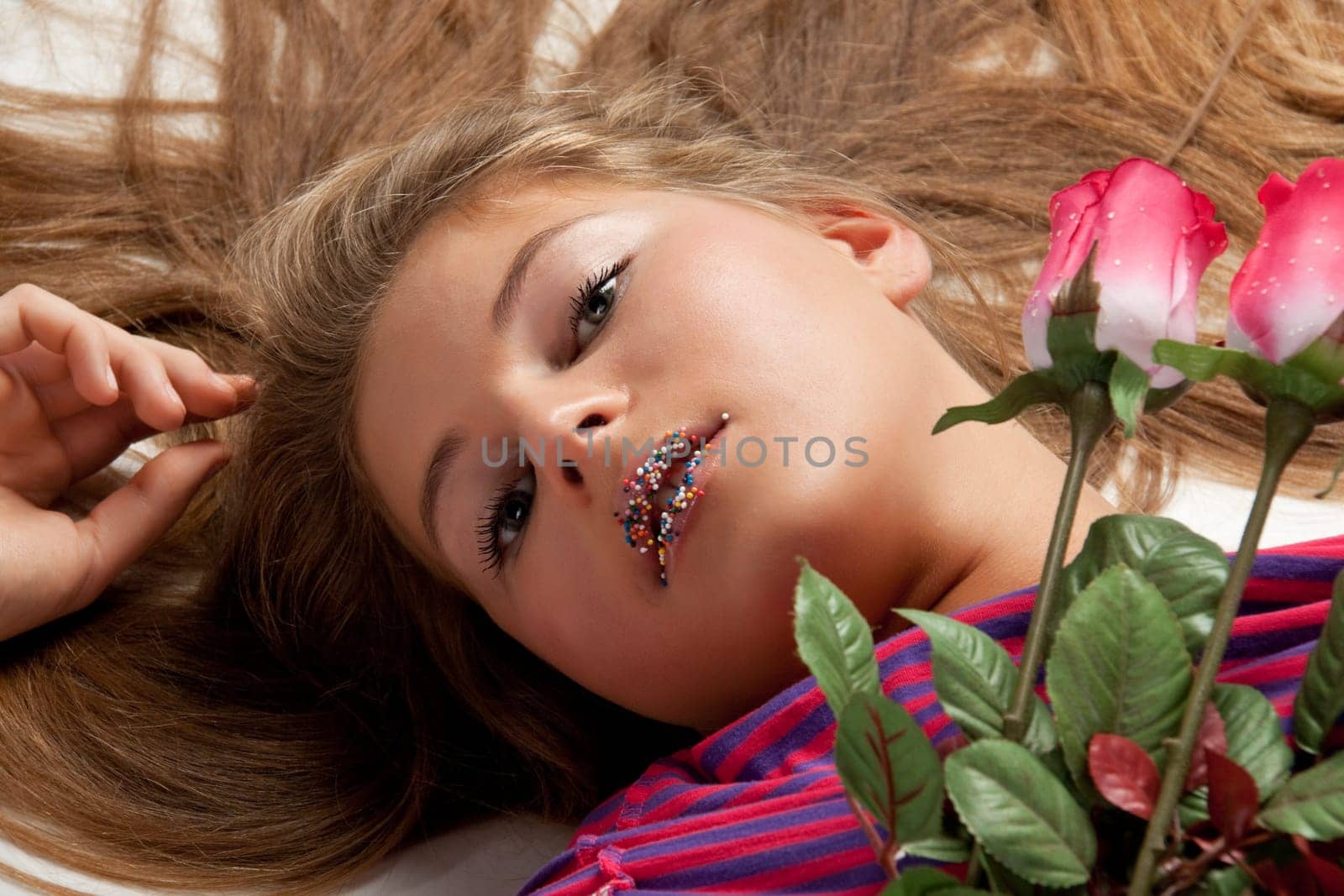 The beautiful girl with a bouquet of roses on a white background.