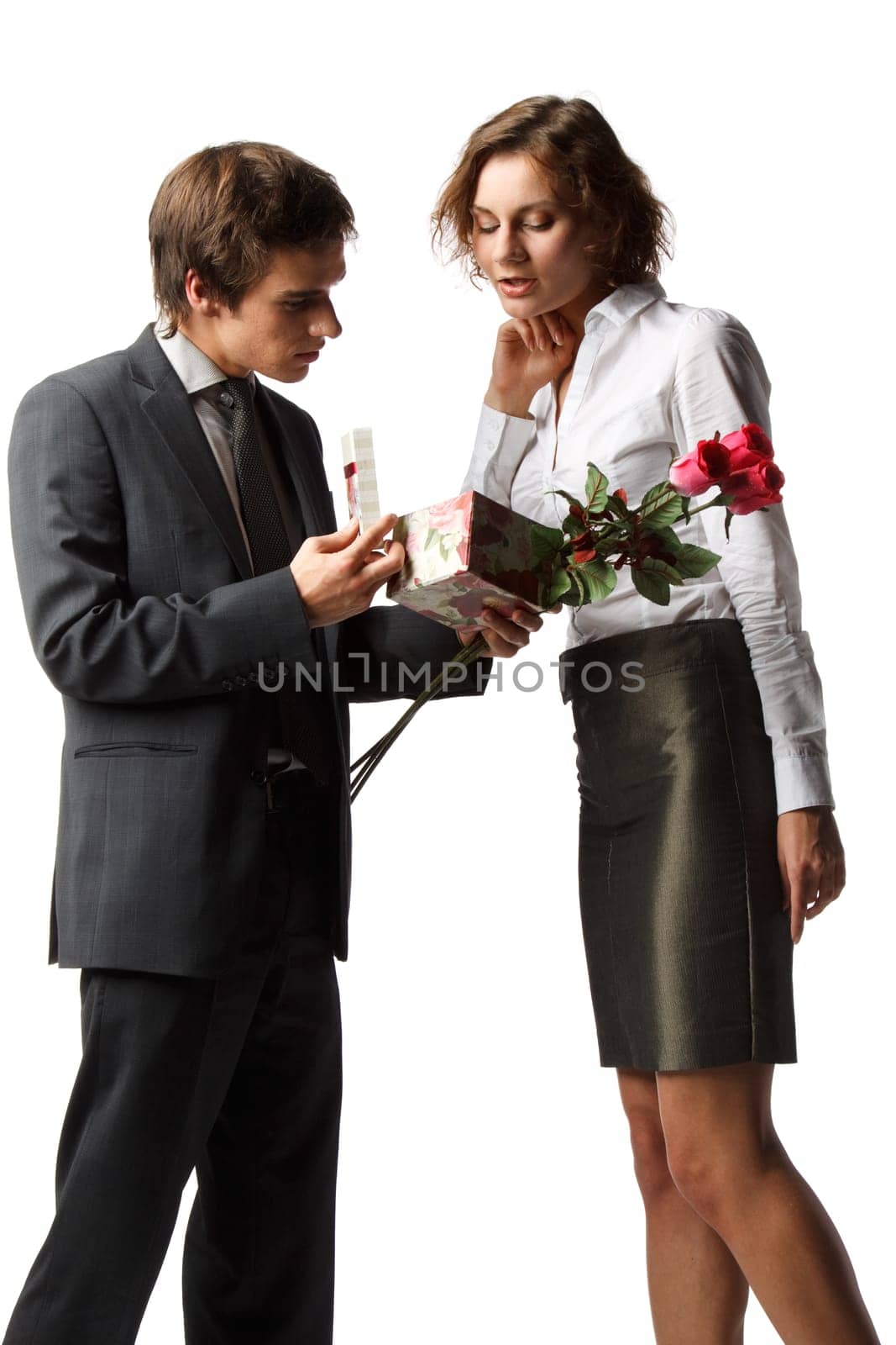 The young enamoured man gives a gift to the girlfriend on a white background.