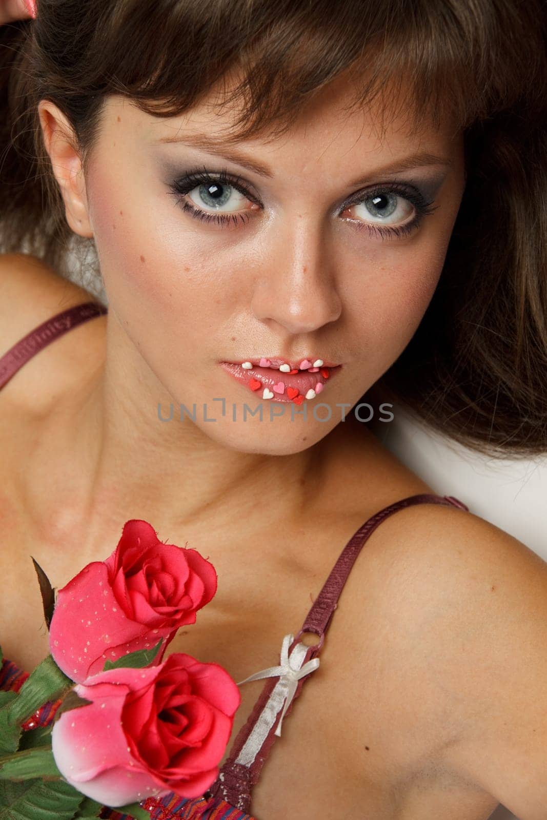 The beautiful girl with a bouquet of roses on a white background.
