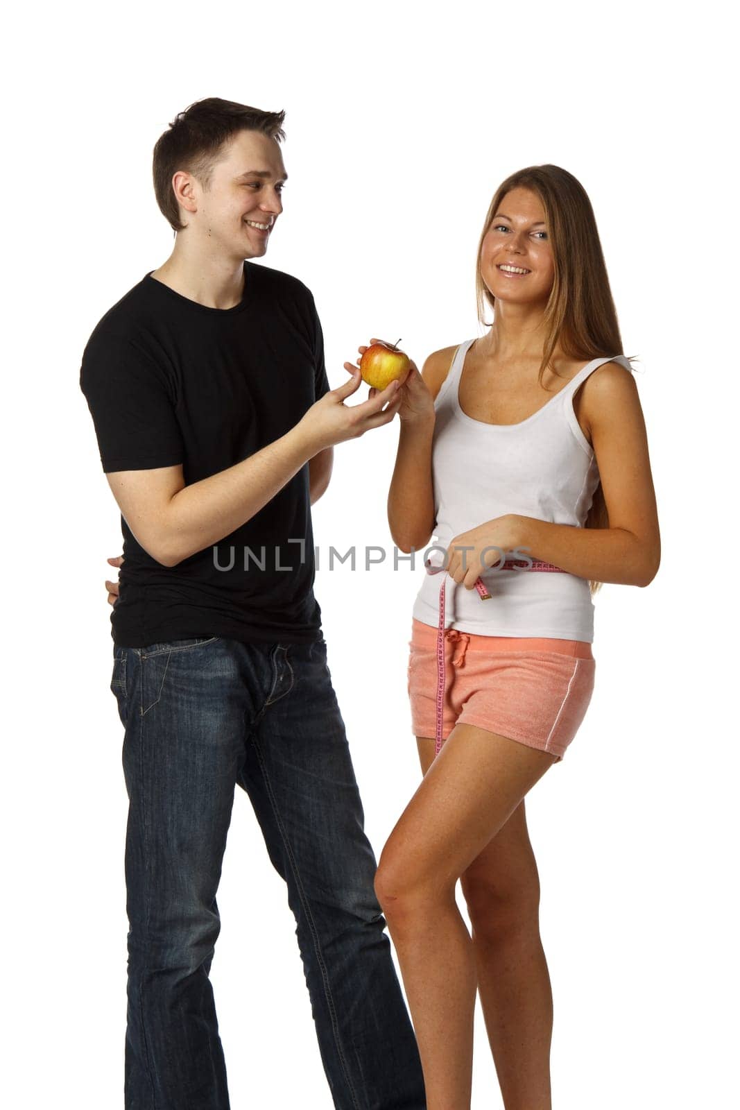 The young man offers an apple to the girl on a white background. Healthy food concept.