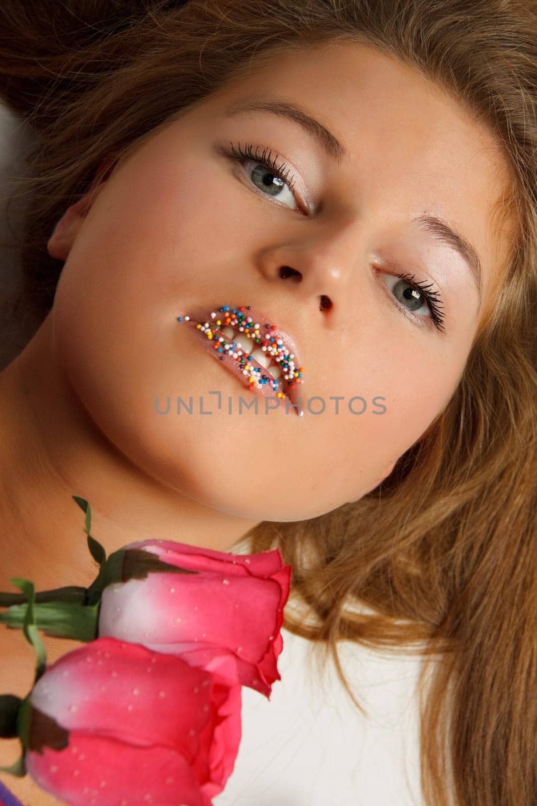 The beautiful girl with a bouquet of roses on a white background.