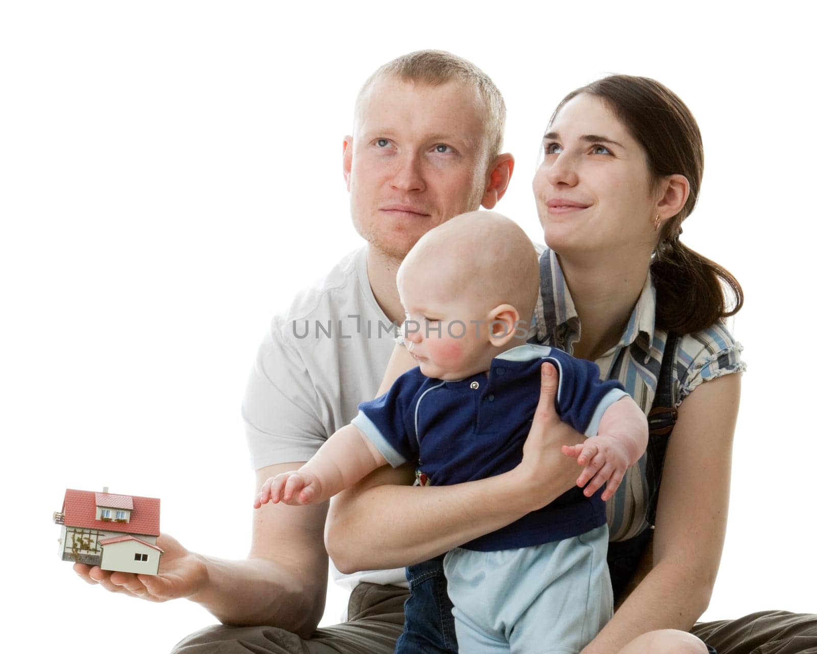 Father with house model, mother and their sweet baby on a white background. Ñoncept of purchase of the house.
