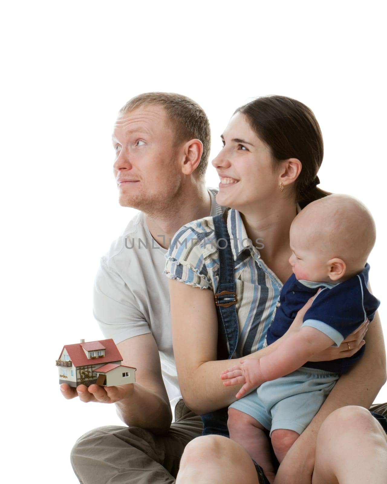 Father with house model, mother and their sweet baby on a white background. Ñoncept of purchase of the house.