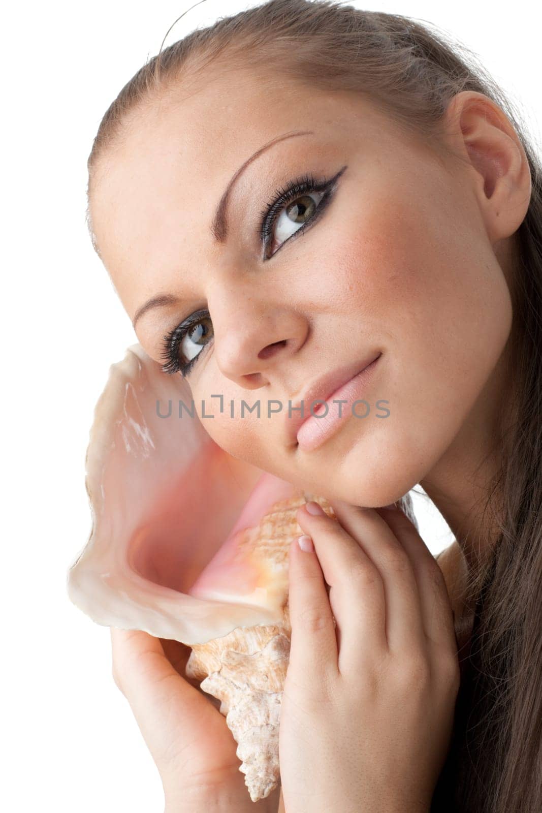 Beautiful woman listens seashell on a white background