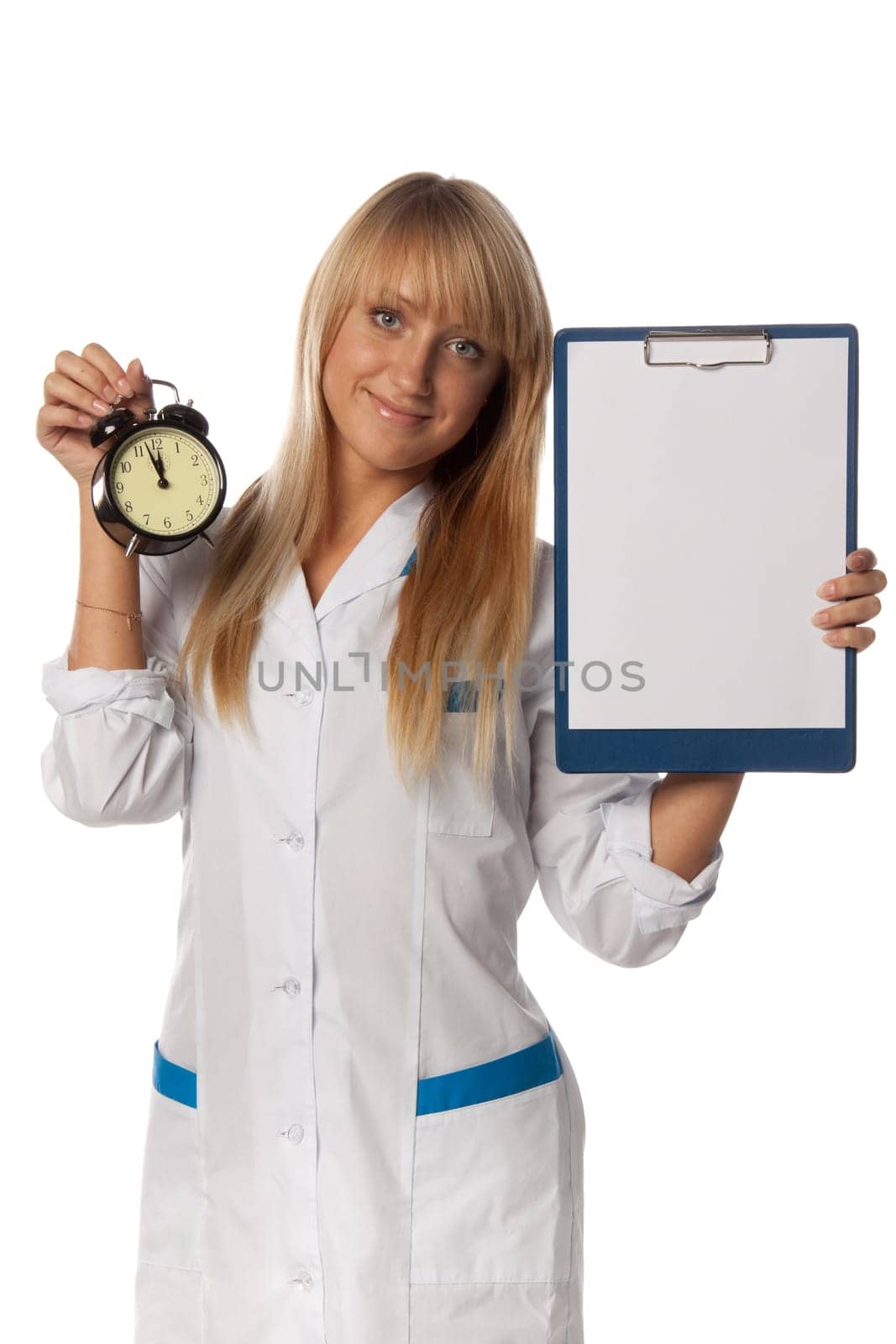 Smiling doctor with blank clipboard and alarm clock in hands on a white background. Medical concept.