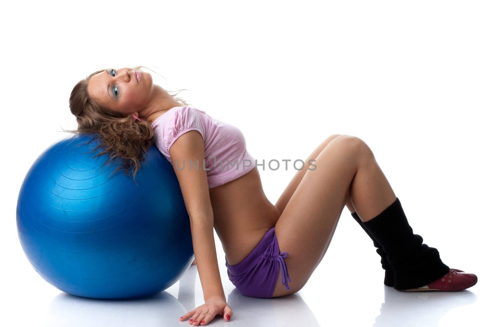 Young beautiful woman with gymnastic ball on a white background.